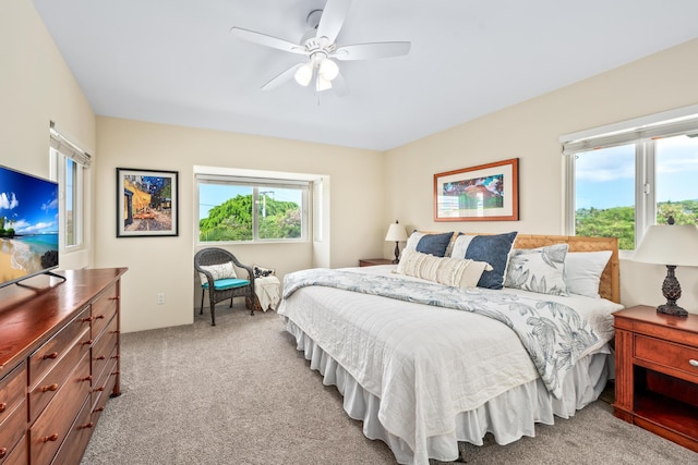 bedroom with light colored carpet and a ceiling fan