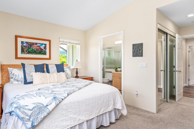 bedroom with connected bathroom, carpet, and vaulted ceiling