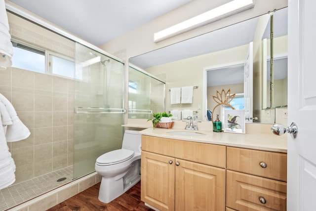 full bath featuring wood finished floors, toilet, a stall shower, and vanity