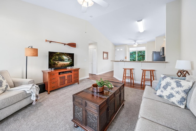 carpeted living room featuring lofted ceiling, a ceiling fan, and baseboards