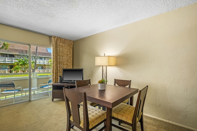 dining area with carpet flooring, a textured wall, and a textured ceiling