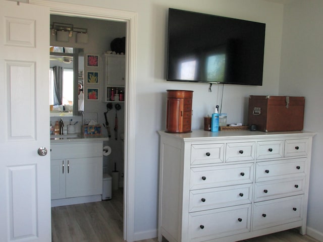 interior space with baseboards, a sink, and light wood-style floors