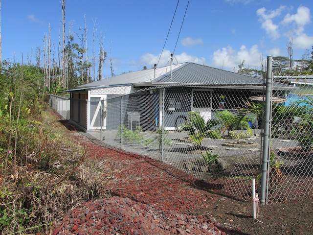 back of house featuring metal roof and fence