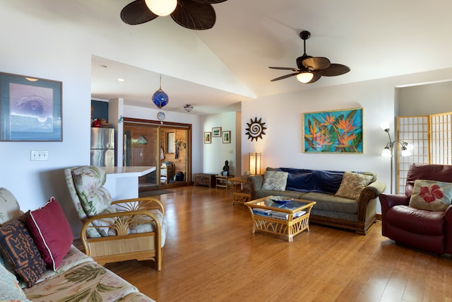 living area featuring a ceiling fan, vaulted ceiling, and wood finished floors