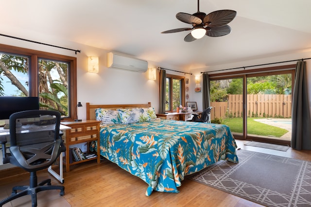 bedroom with a wall unit AC, wood finished floors, lofted ceiling, and access to exterior