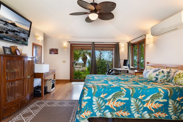 bedroom with access to exterior, an AC wall unit, vaulted ceiling, wood finished floors, and a ceiling fan