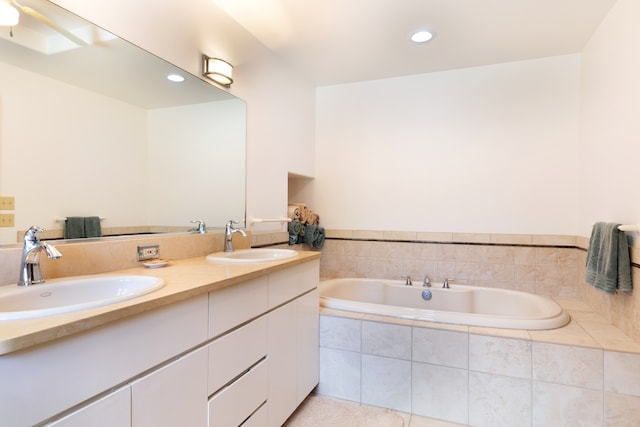 full bath featuring a garden tub, recessed lighting, double vanity, and a sink