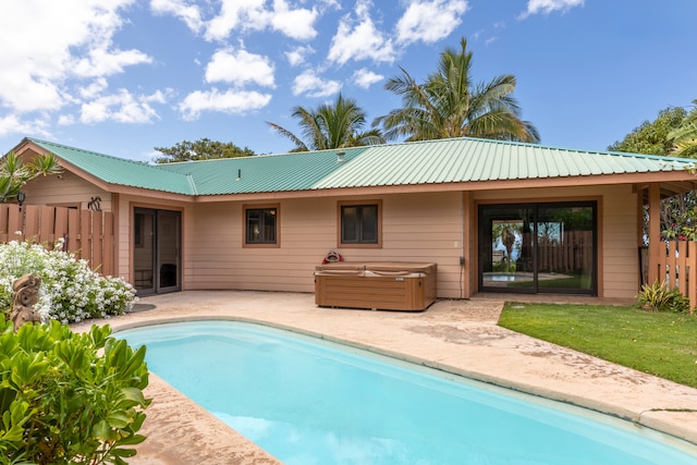 back of property featuring fence, a hot tub, metal roof, a fenced in pool, and a patio