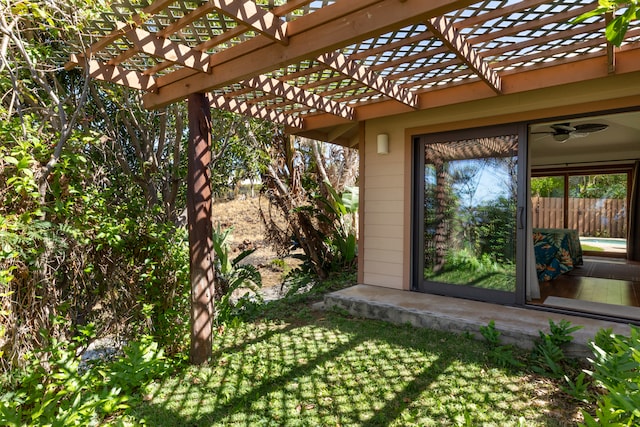 view of yard with fence, a ceiling fan, and a pergola