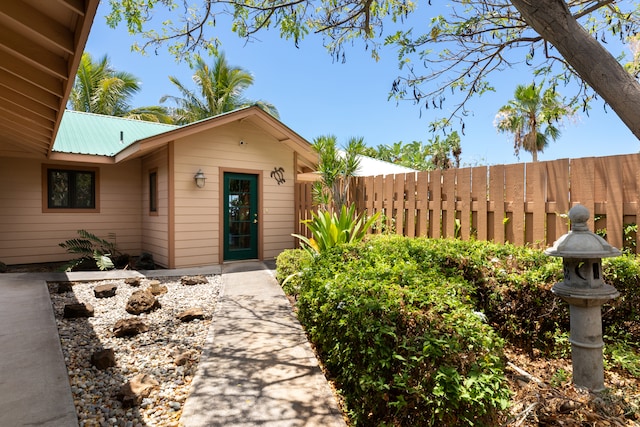 entrance to property with metal roof and fence
