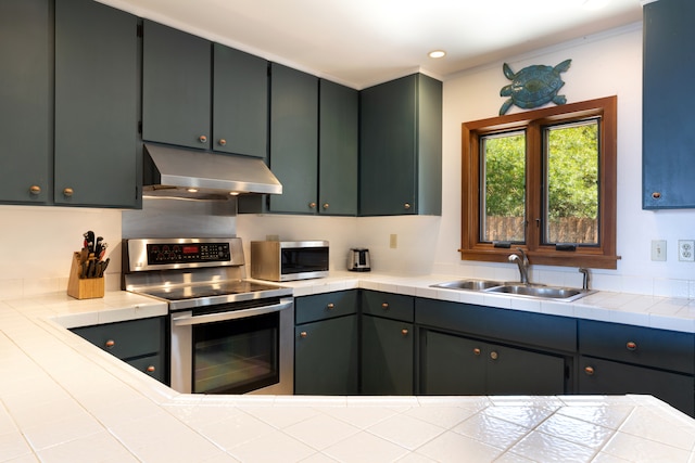 kitchen with recessed lighting, a sink, stainless steel appliances, and under cabinet range hood