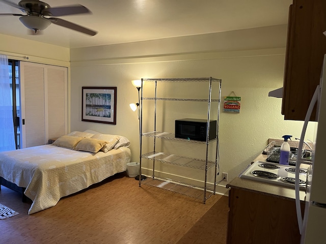 bedroom featuring a closet, a ceiling fan, wood finished floors, and a textured wall