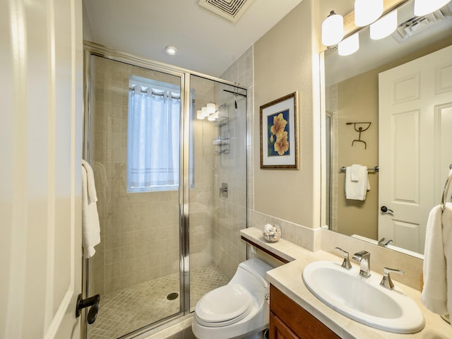 bathroom featuring visible vents, vanity, a shower stall, and toilet