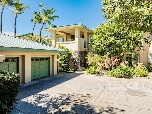 view of front of property with stucco siding, decorative driveway, and a garage