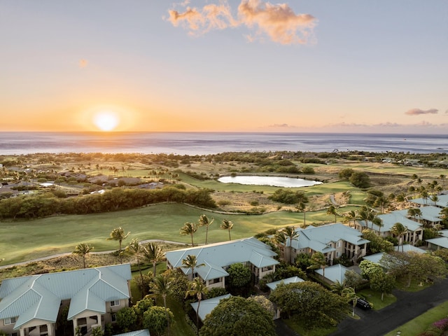 aerial view at dusk featuring a water view