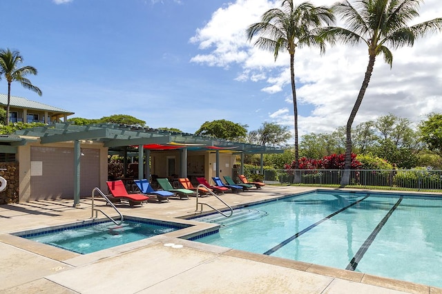 pool featuring fence, a hot tub, and a patio area