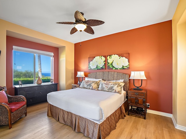 bedroom with a ceiling fan, baseboards, and wood finished floors