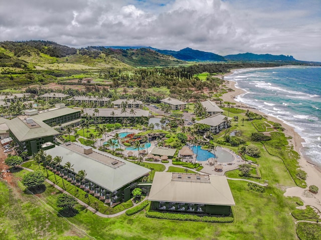 drone / aerial view featuring a water and mountain view and a beach view