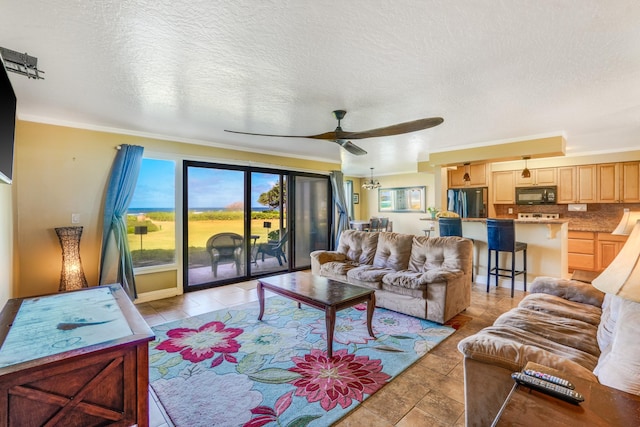 living area with a textured ceiling, crown molding, and a ceiling fan