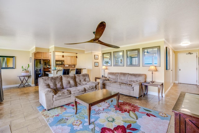 living room featuring baseboards, a ceiling fan, and ornamental molding