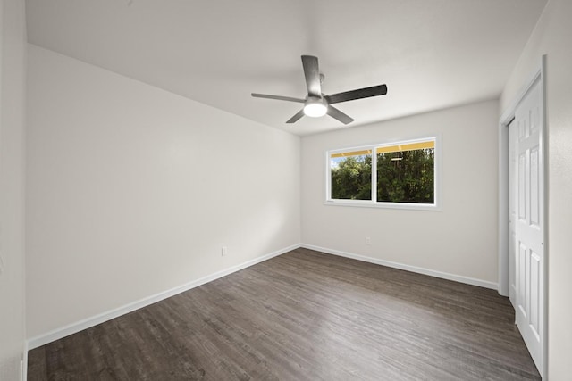 unfurnished bedroom featuring a ceiling fan, a closet, dark wood finished floors, and baseboards