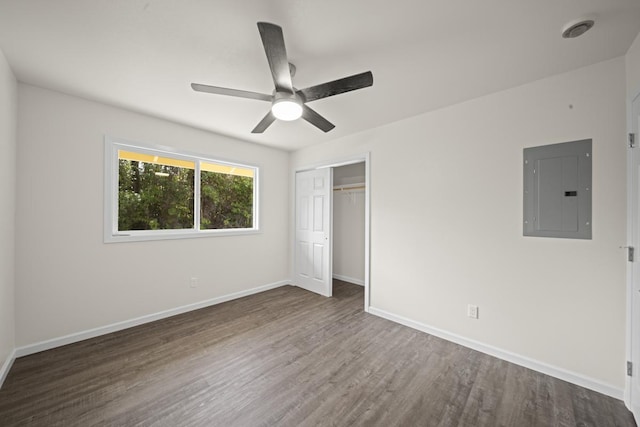 unfurnished bedroom with ceiling fan, wood finished floors, baseboards, a closet, and electric panel