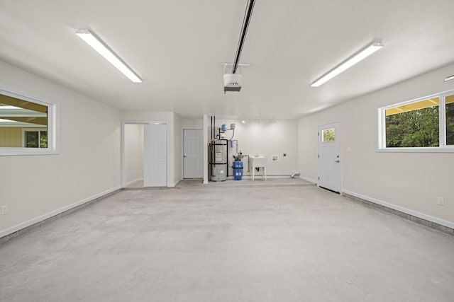 garage featuring water heater, baseboards, a sink, and a garage door opener