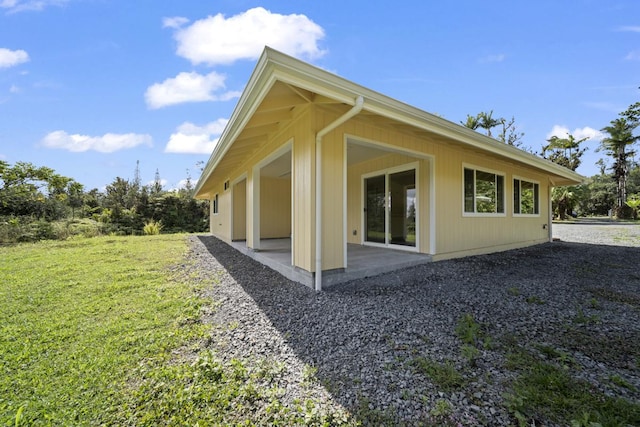 back of house featuring a patio and a yard