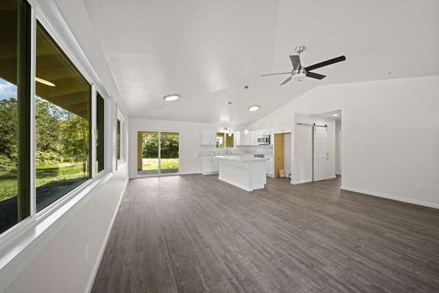 unfurnished living room with vaulted ceiling, dark wood finished floors, baseboards, and ceiling fan