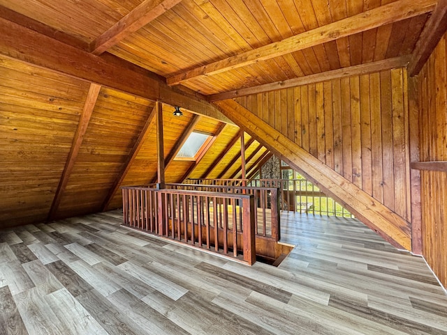 additional living space with wooden ceiling, lofted ceiling with skylight, and wood finished floors