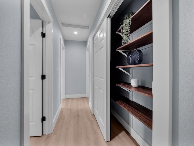 hallway featuring attic access, recessed lighting, light wood-style flooring, and baseboards