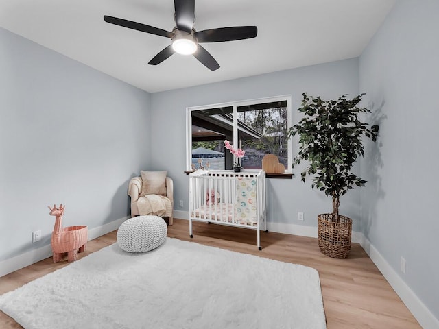 bedroom with ceiling fan, baseboards, and wood finished floors