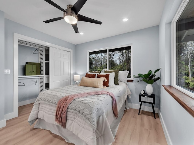 bedroom featuring multiple windows, baseboards, and wood finished floors