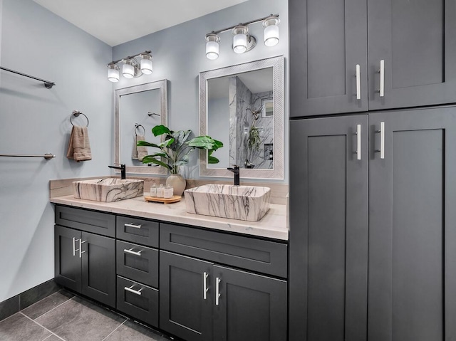 bathroom with double vanity, tile patterned flooring, baseboards, and a sink