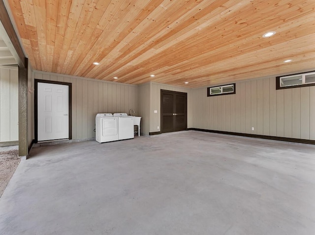 below grade area featuring a sink, wooden ceiling, washing machine and clothes dryer, and recessed lighting