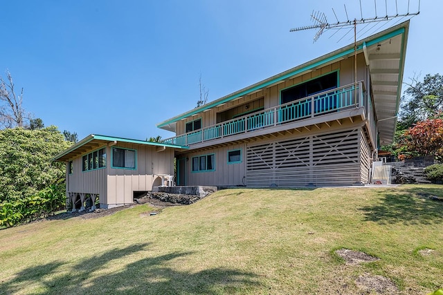 rear view of property with a yard, board and batten siding, and a balcony