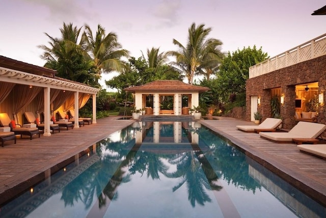 outdoor pool featuring an outbuilding, an exterior structure, and a wooden deck