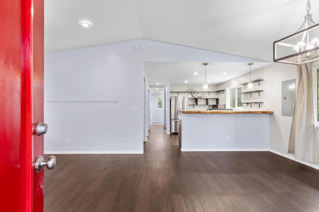 kitchen with an inviting chandelier, dark wood finished floors, freestanding refrigerator, and electric panel