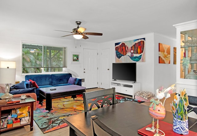 living room featuring crown molding, wood finished floors, and ceiling fan