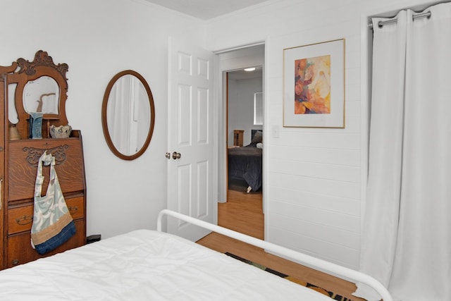 bedroom featuring crown molding and wood finished floors