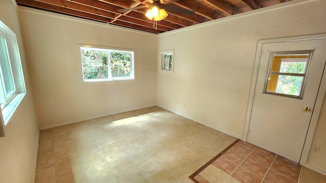 spare room featuring beam ceiling and baseboards