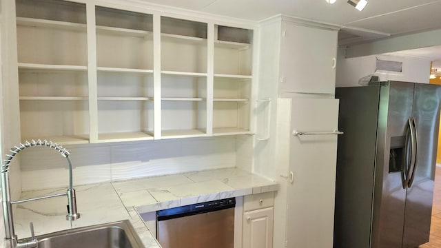 kitchen with appliances with stainless steel finishes, light countertops, and a sink