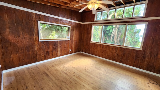 empty room featuring wood walls and wood-type flooring