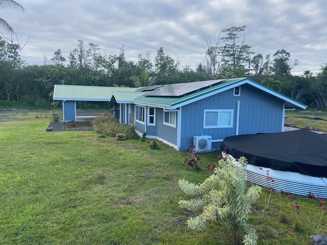 15-1509 22nd Ave, Keaau, HI 96749 - view of side of home featuring ac unit, solar panels, a lawn, and metal roof