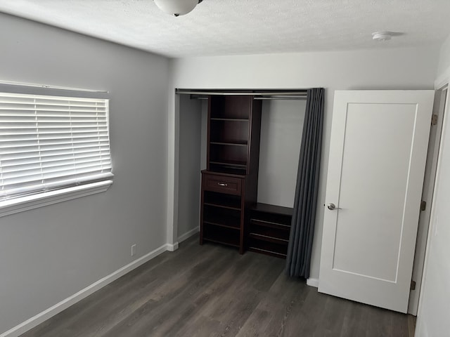 15-1509 22nd Ave, Keaau, HI 96749 - unfurnished bedroom featuring dark wood-style floors, a closet, a textured ceiling, and baseboards