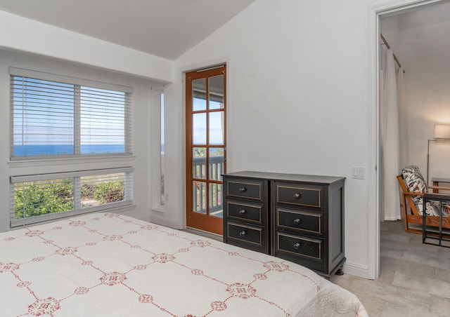 bedroom with lofted ceiling and baseboards