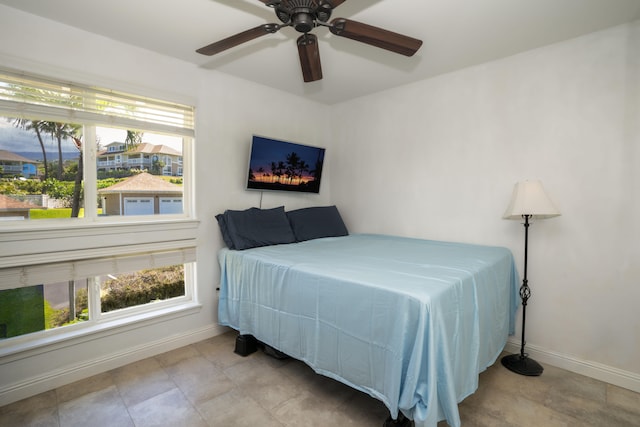 bedroom featuring multiple windows, ceiling fan, and baseboards