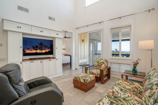 living room featuring visible vents and a towering ceiling