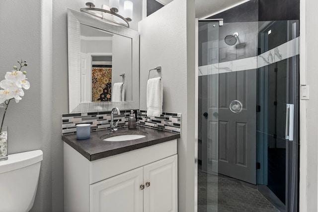 bathroom featuring tasteful backsplash, a stall shower, vanity, toilet, and a textured wall