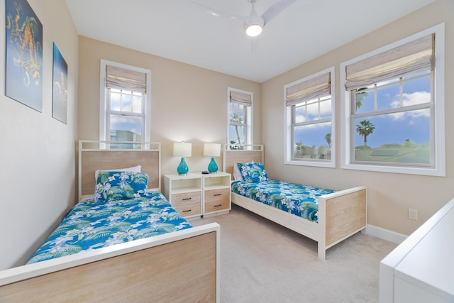 bedroom with multiple windows, baseboards, a ceiling fan, and carpet floors